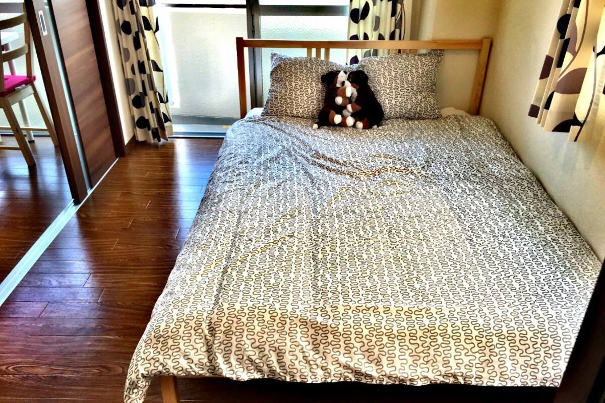 A bed with patterned bedding, wooden headboard, and two pillows.