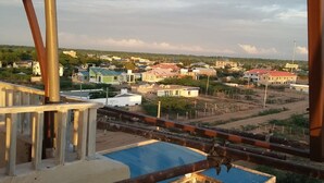 A view from a window overlooking a residential area with houses and a clear sky.