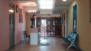 A spacious lobby with a reception desk, seating area, and a patterned floor.