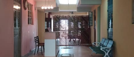 A spacious lobby with a reception desk, seating area, and a patterned floor.