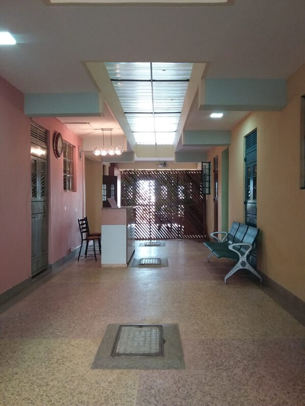 Un hall amplio con una recepción, zona de estar y suelo estampado.