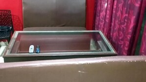 A room with a bed, a glass-top table, and a red wall. - Yelagiri Residency (Tirupattur)