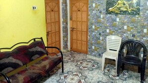 A room with a patterned floor, a sofa, two doors, and a mosaic wall. - Yelagiri Residency (Tirupattur)