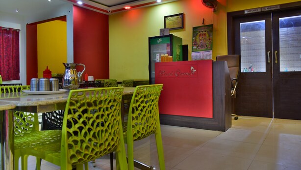 A restaurant with a red counter, green chairs, and a kitchen area with a sign reading "No Admission". - Yelagiri Residency (Tirupattur)
