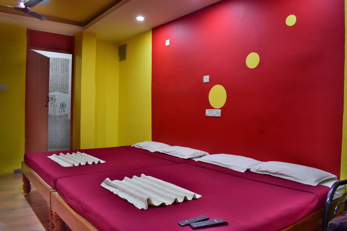 A room with a bed, a red wall, and a yellow wall.