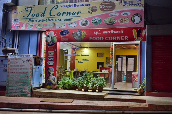 A multi cuisine vegetarian restaurant named 'Food Corner' with a signboard displaying various dishes and a contact number. - Yelagiri Residency (Tirupattur)