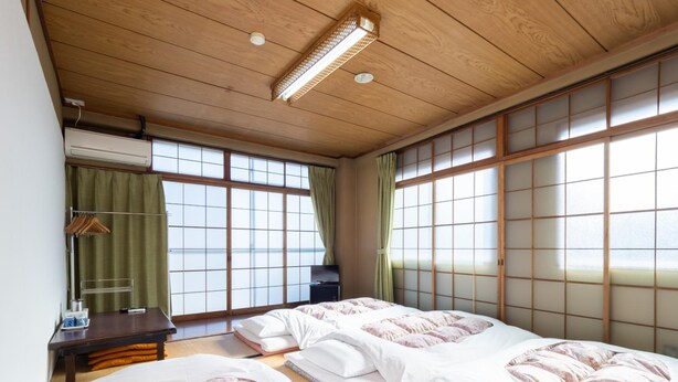A traditional Japanese-style room with tatami flooring, sliding shoji doors, and a wooden ceiling. - Business Hotel Nakayama (Nagoya)