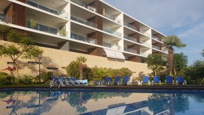 A hotel with a swimming pool, blue lounge chairs, and a stone facade. - FABULOUS 2 BED LUXURY APARTMENT, GREAT VIEWS, MARINA VILLAGE, 120M2 (Lagos)
