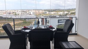 A balcony with a table and chairs, overlooking a cityscape. - FABULOUS 2 BED LUXURY APARTMENT, GREAT VIEWS, MARINA VILLAGE, 120M2 (Lagos)