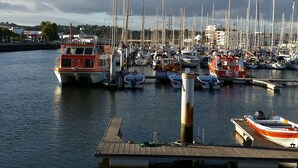 A marina with multiple boats docked, a wooden pier, and a backdrop of buildings and hills. - FABULOUS 2 BED LUXURY APARTMENT, GREAT VIEWS, MARINA VILLAGE, 120M2 (Lagos)