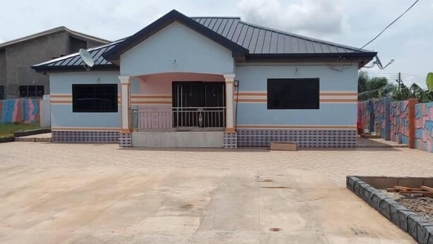 A two-story building with a flat roof and a central entrance. - Dukusguest (Kumasi)