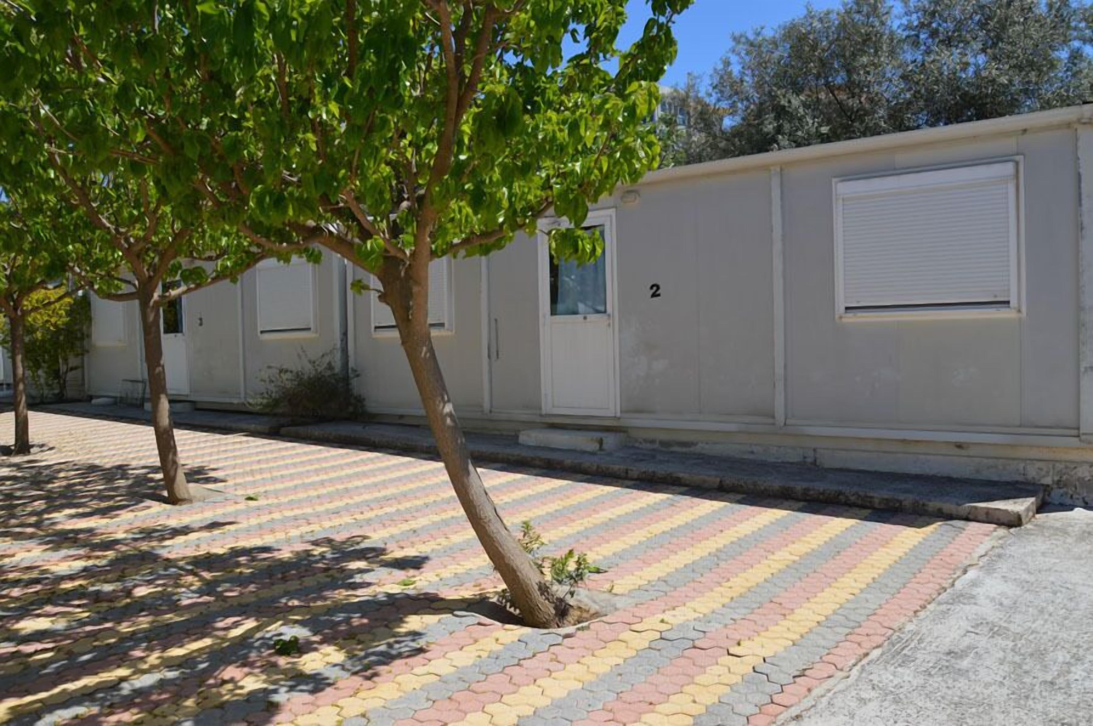 A row of single-story buildings with a tiled walkway.