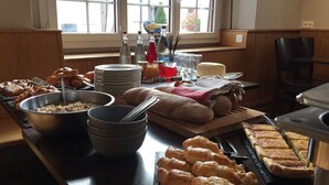 Un bufé de desayuno con panes, pasteles y diversas opciones para el desayuno.