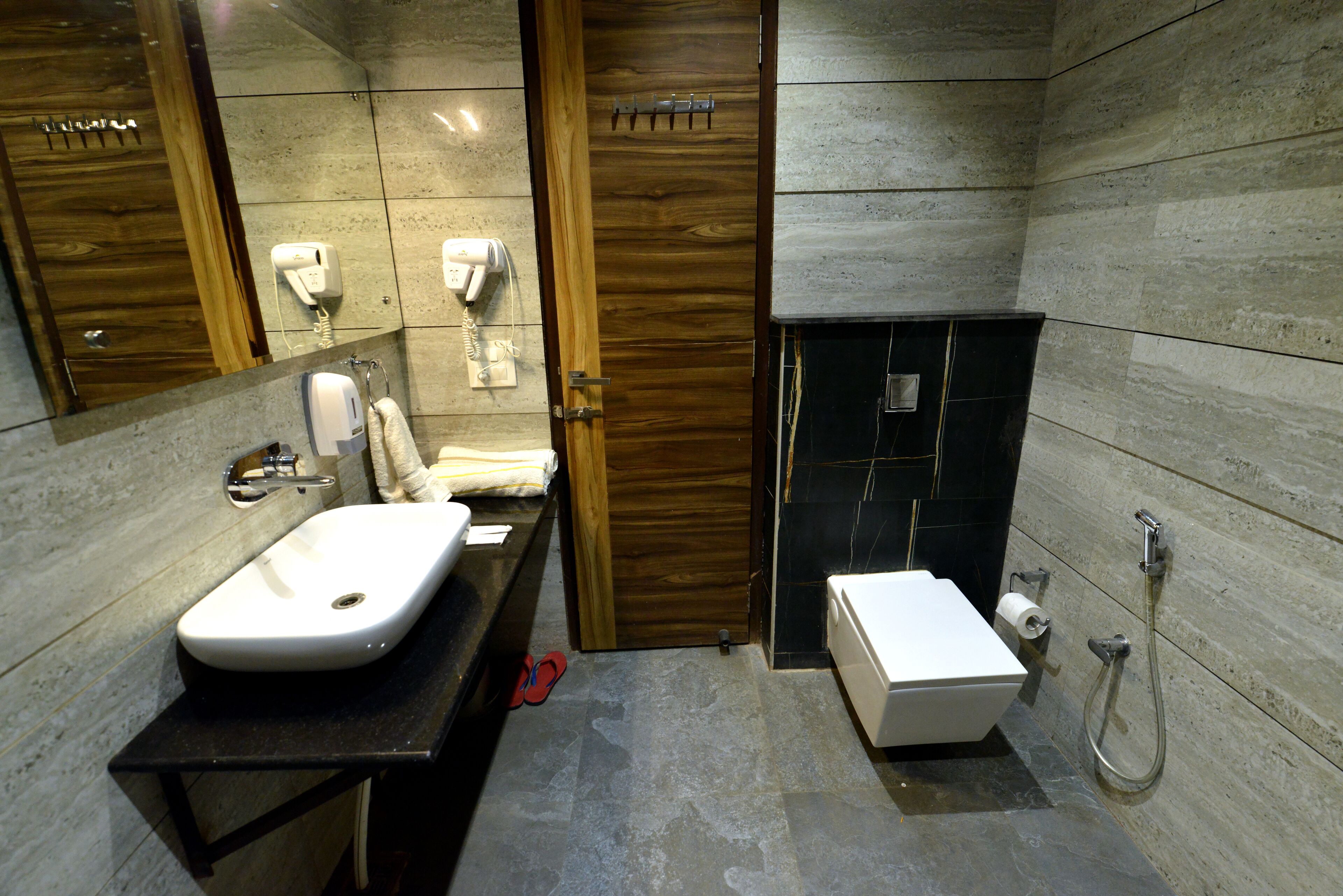 Un baño moderno con lavamanos, inodoro y ducha.