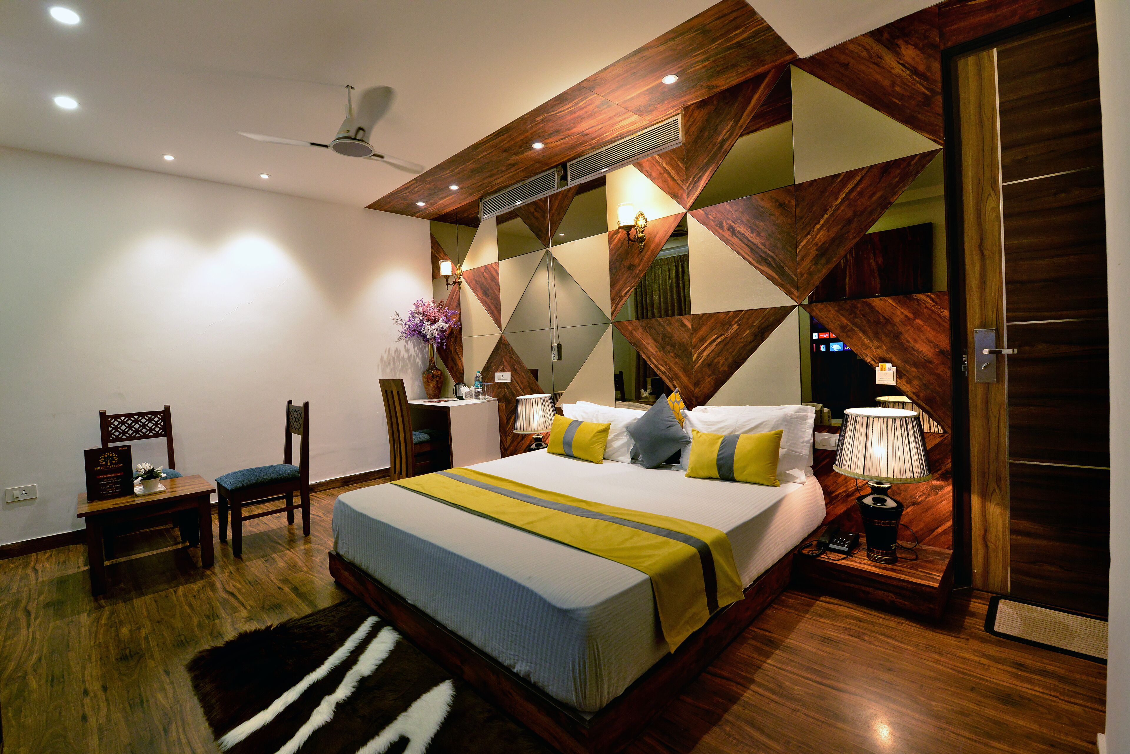 Een moderne hotelkamer met een groot bed, een bureau en een stoel.