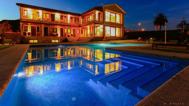 A two-story building with a swimming pool in front. - Hotel A Maquía (Poio)