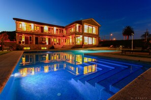 Un bâtiment à deux étages avec une piscine devant.