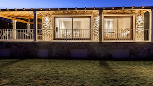 A stone building with large windows and a covered patio area. - Hotel A Maquía (Poio)
