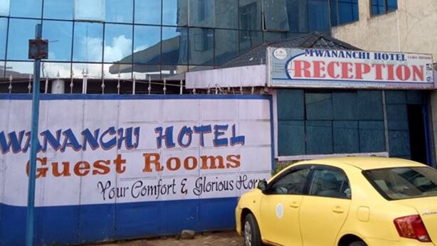 En moderne hotelbygning med en glasfacade og et skilt til receptionen.