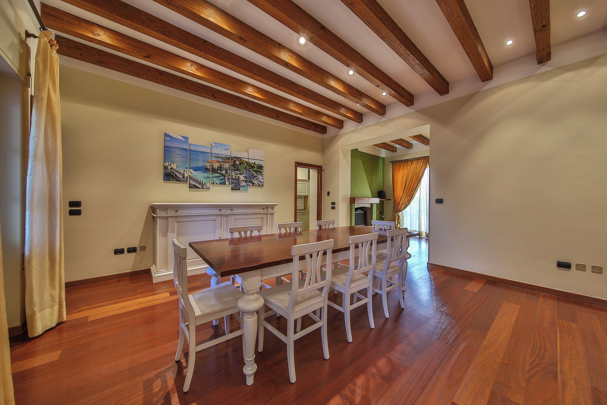 Un comedor con una mesa y sillas de madera, un cuadro en la pared y una chimenea.