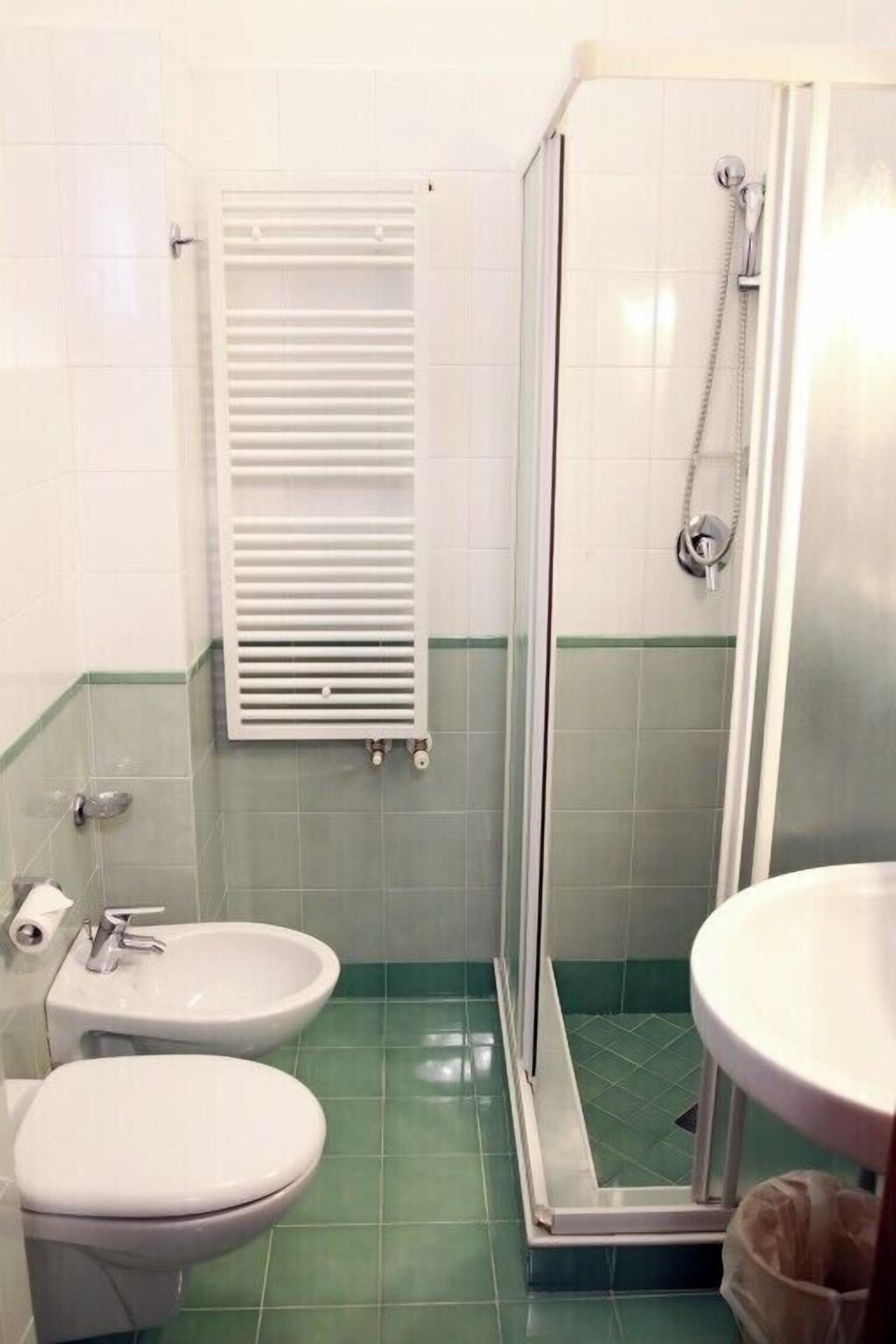 Un bagno con doccia, WC e lavandino.