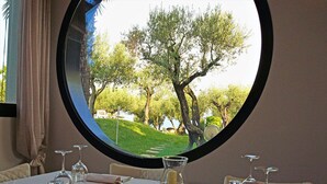 Una mesa de comedor con vistas a un sendero arbolado a través de una ventana.
