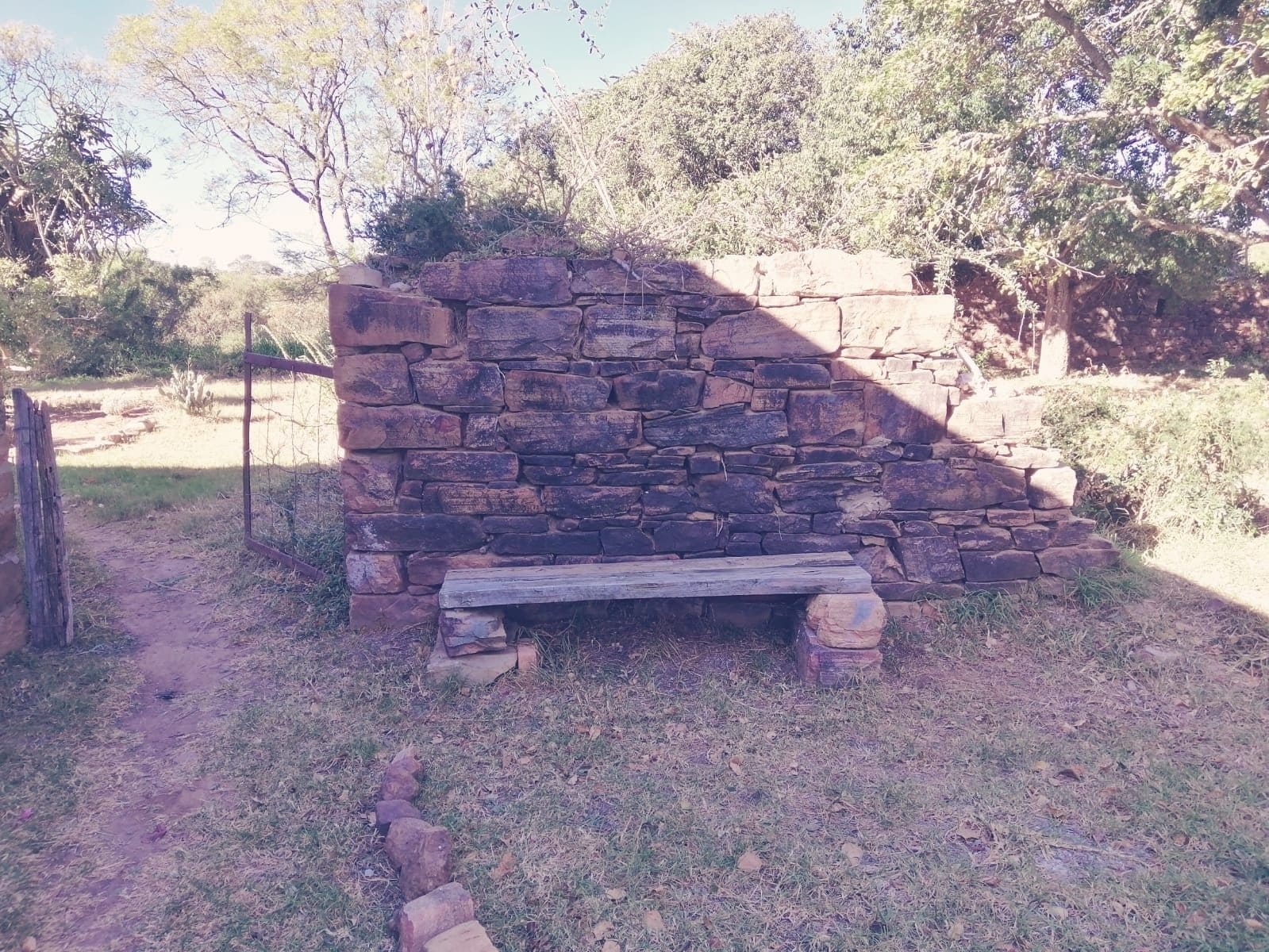 Un muro de piedra con un banco al frente.
