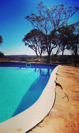 Una piscina al aire libre, sillones reclinables de piscina