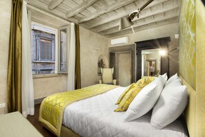 A bedroom with a bed, a window, a chair, and an air conditioning unit. - Santa Caterina Relais (Rome)