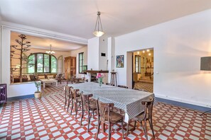 A spacious dining area with a large table, chairs, and a patterned floor. - 🌿 Mas d'exception en Provence - 3 houses, 2 swimming pools, boules court (Beaucaire)