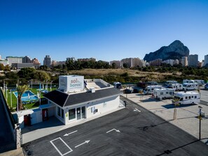 Parque vacacional para campistas y viajeros con caravana, con piscina, aparcamiento para autocaravanas y vistas a la ciudad y la montaña.