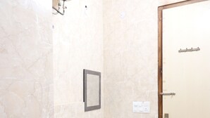 A small bathroom with a toilet, sink, and mirror. - Winsome Residency (Noida)