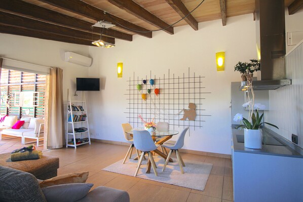A modern living room with a dining area, a TV mounted on the wall, and a kitchen with a plant on the counter. - FINCA "CUCA". (SON VENT, ETV/4997.) SAUNA, JACUZZY.... (Sa Pobla)