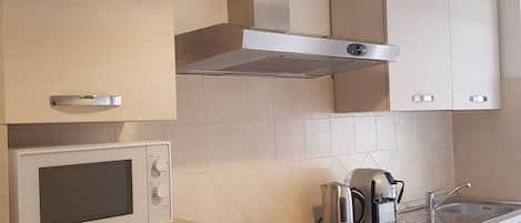 Een magnetron, een oven, een kookplaat, een koffiezetapparaat/waterkoker