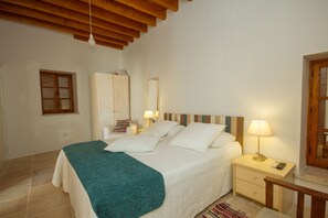 A bedroom with a bed, bedside tables, a wardrobe, and a mirror. - Thyone Uno Cottage (Vavla)