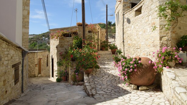 A narrow stone pathway flanked by buildings with stone walls and wooden doors. - Thyone Uno Cottage (Vavla)