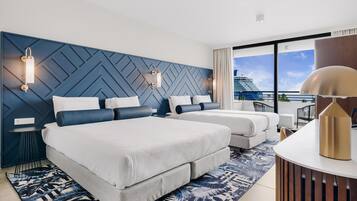 Habitación de hotel con dos camas, un ventanal con vista a un crucero y un diseño moderno en la pared.