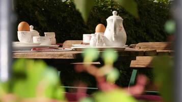 Una mesa de madera con juego de té de cerámica blanca y una taza de té.