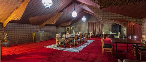Un dormitorio en ático con alfombra roja, muebles de madera y paredes con diseño.