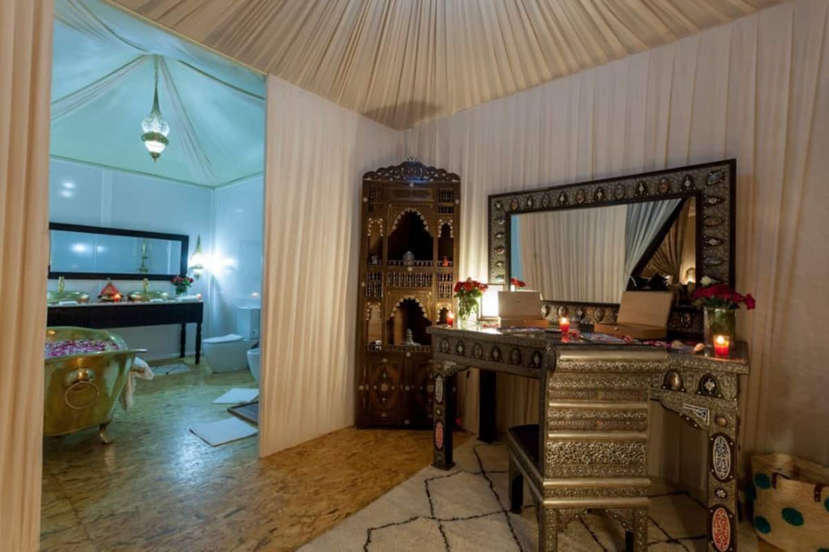 A room with a traditional wooden cabinet, a mirror, and a table with candles.