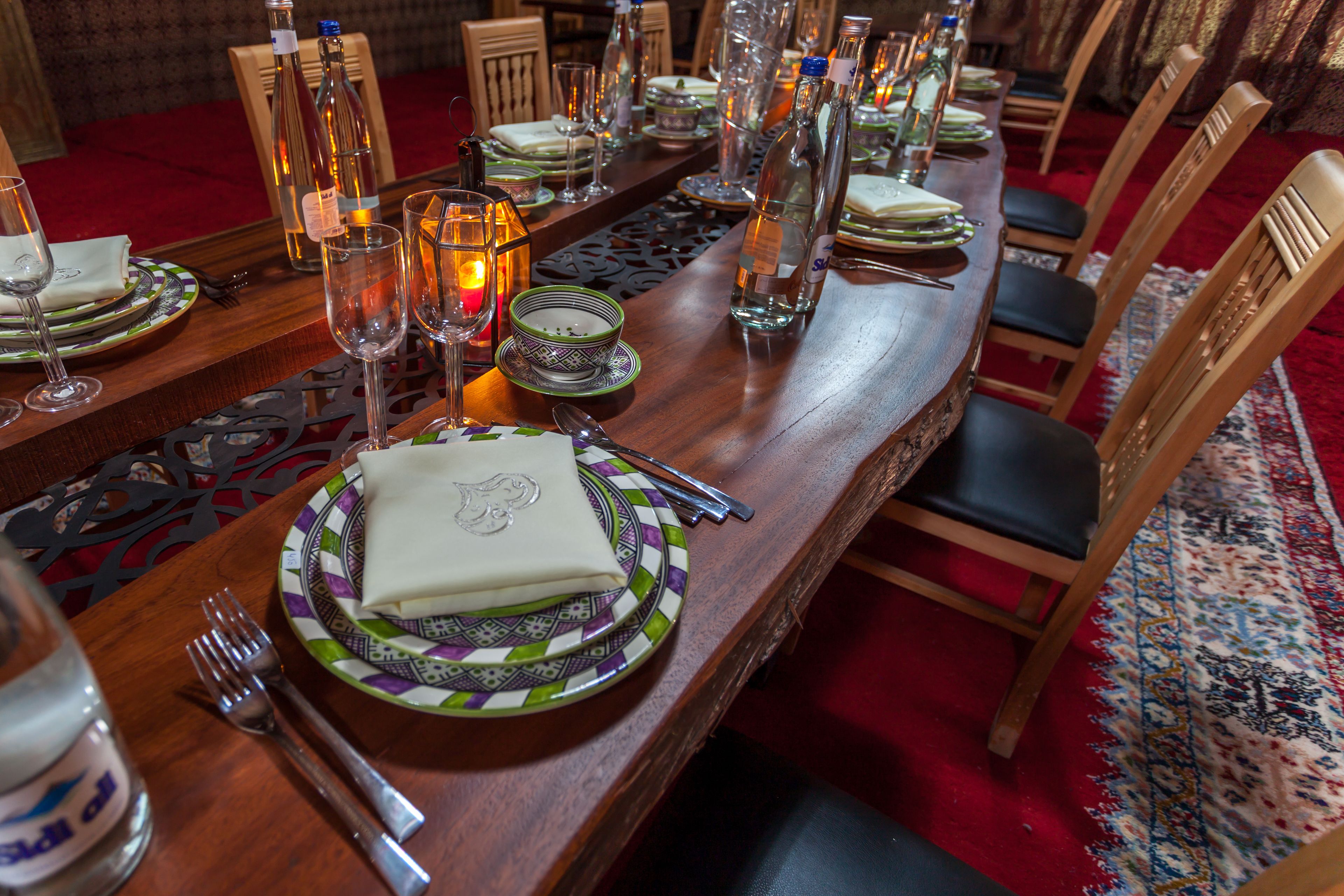 A formal dining table set with plates, glasses, cutlery, and candles.