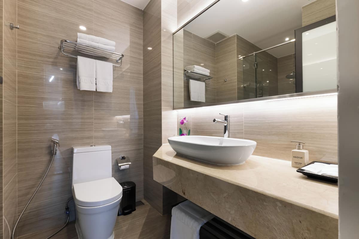 A modern bathroom with a toilet, sink, and shower.