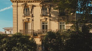 Un bâtiment de style classique, doté de balcons richement décorés et d’une façade symétrique.
