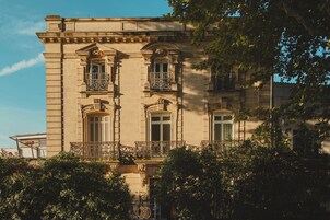 Un edificio clásico con balcones ornamentados y una fachada simétrica.