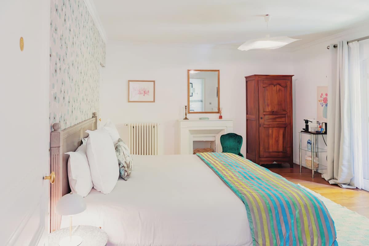 Un dormitorio con cama, cómoda, silla y escritorio.