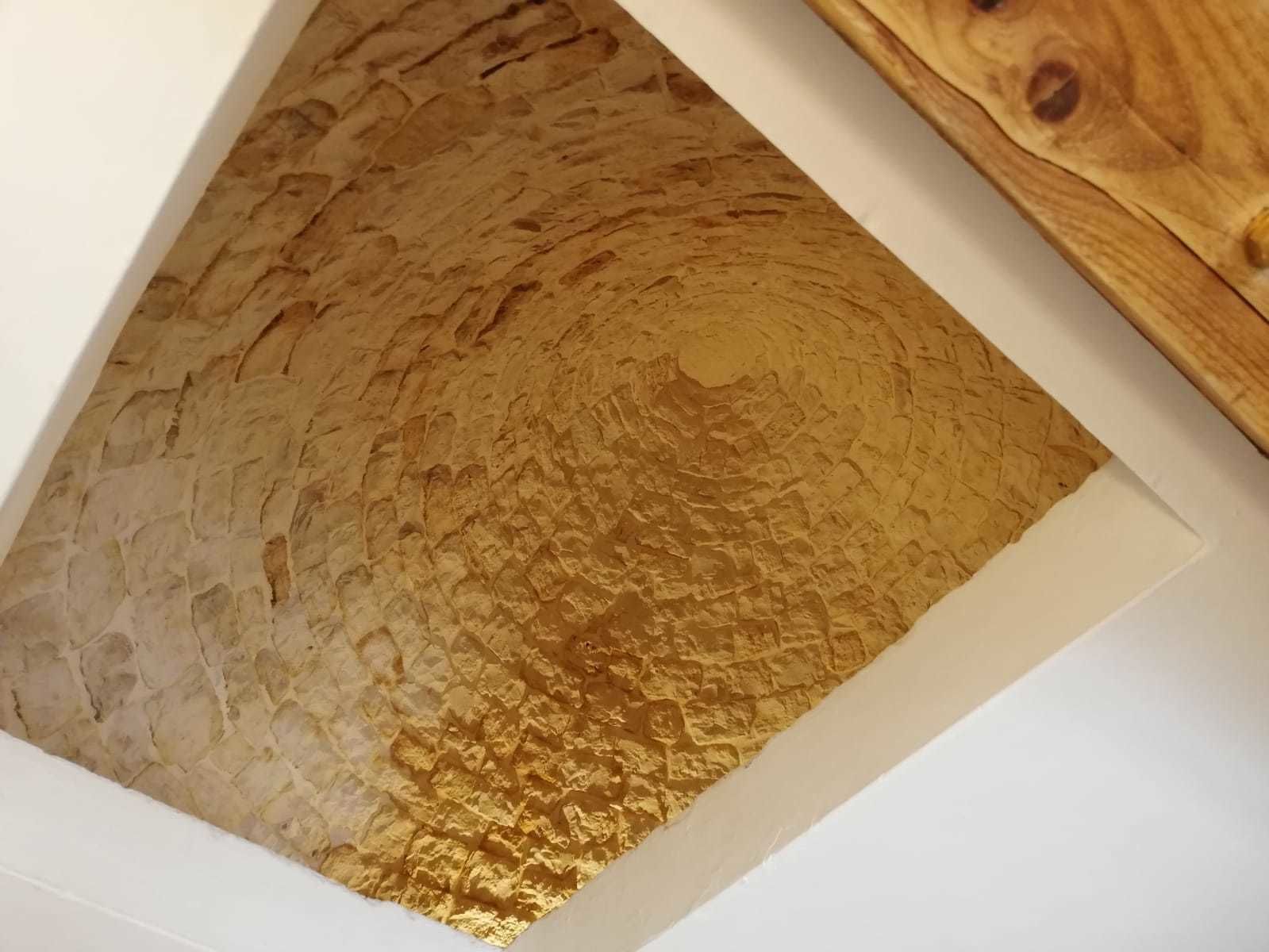 A textured wall with a wooden panel.