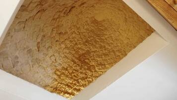 A textured wall with a wooden panel.