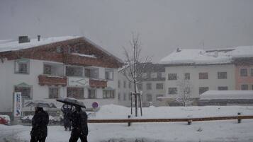 Ein Gebäude mit schneebedecktem Dach und einem Schild mit der Aufschrift 'INTERSPORT ARLBEG'.