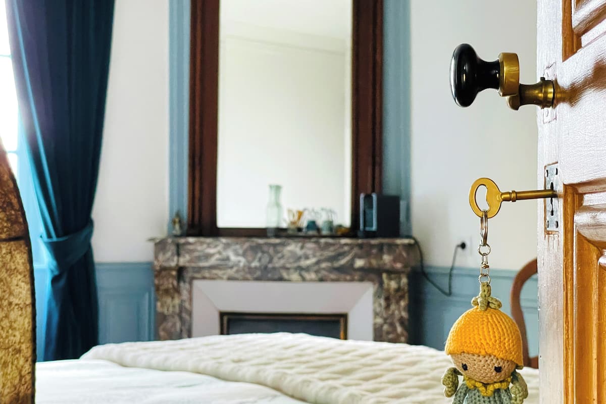 Une chambre à coucher avec un lit, une cheminée et un porte-clés accroché à la porte.