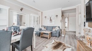 A modern living room with a grey sofa, a wooden coffee table, and a fur rug. - Ferienwohnungen Casa Bella Cosa (Braunlage)